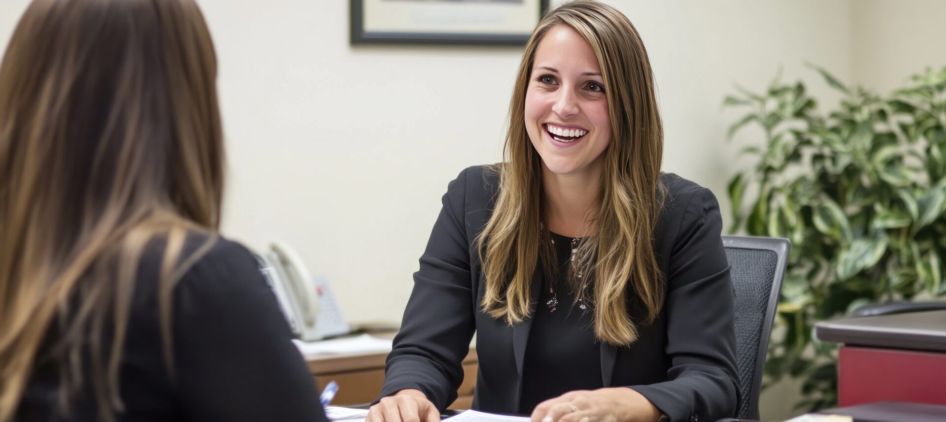 Happy businesswoman consulting with a client in her office