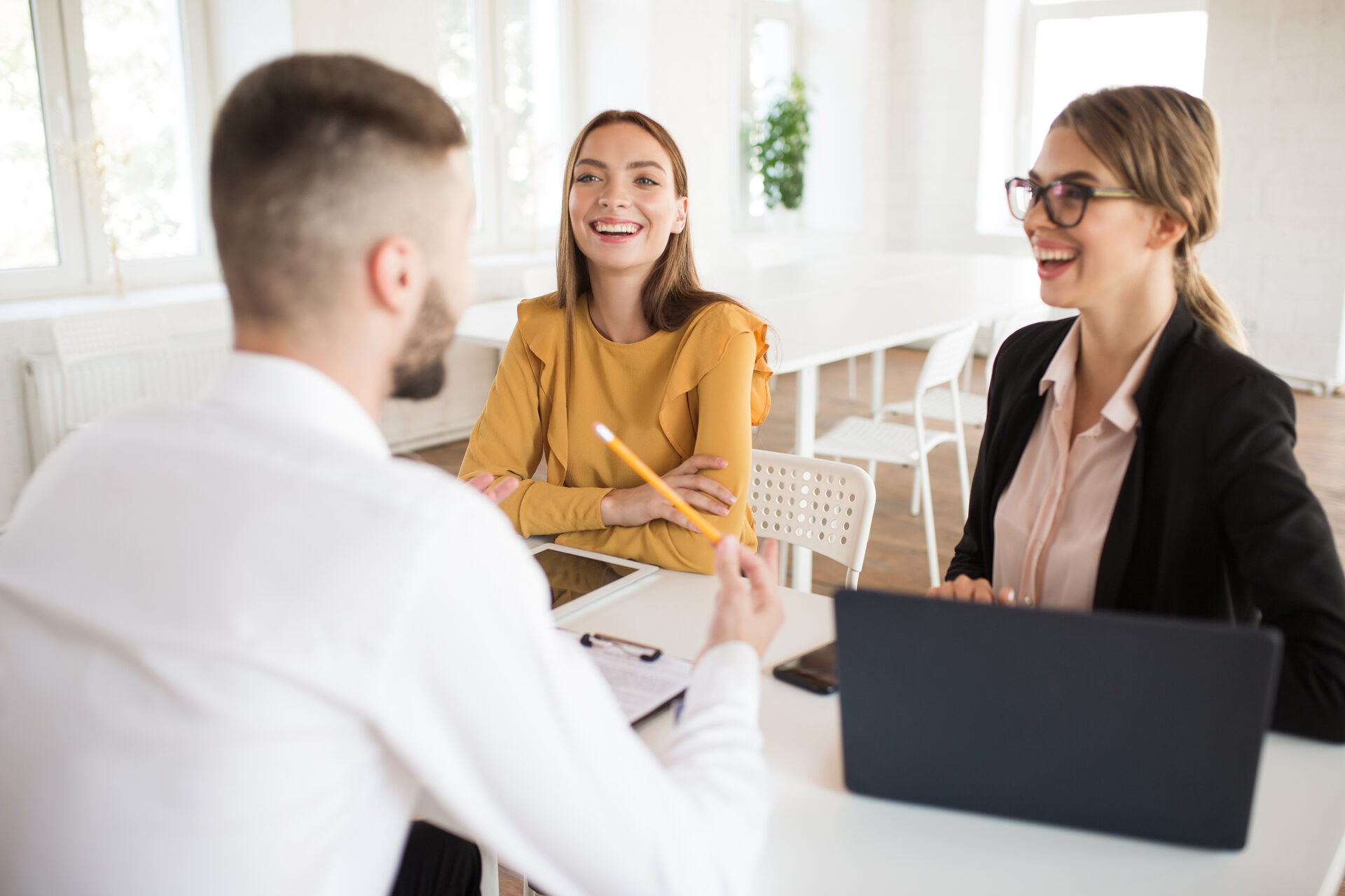 Two business women interviewing a male job applicant
