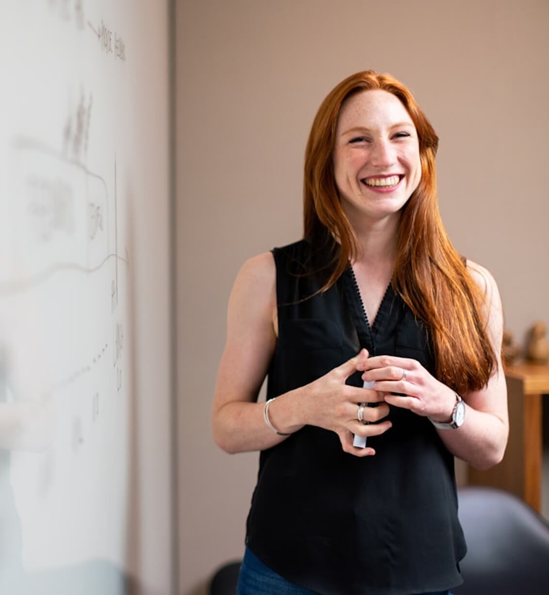 Smiling woman presenting at whiteboard